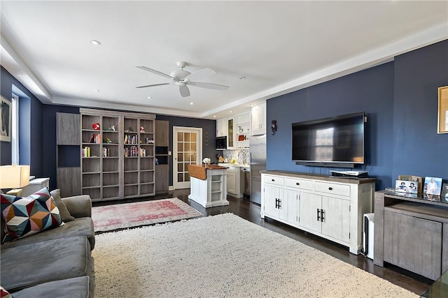 living room featuring dark hardwood / wood-style flooring and ceiling fan