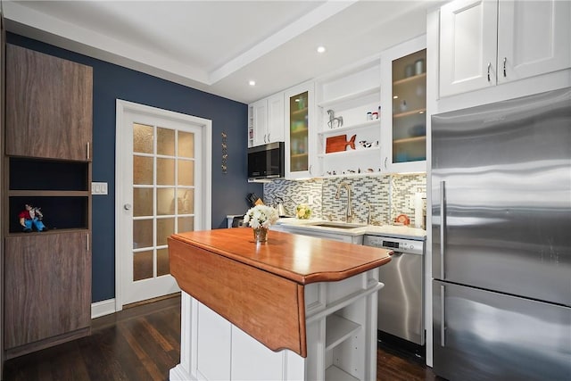 kitchen with white cabinetry, sink, stainless steel appliances, dark hardwood / wood-style floors, and backsplash