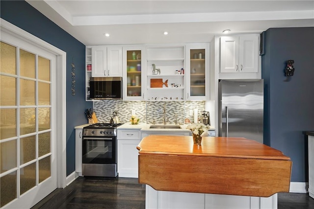 kitchen with sink, dark hardwood / wood-style floors, decorative backsplash, white cabinets, and appliances with stainless steel finishes