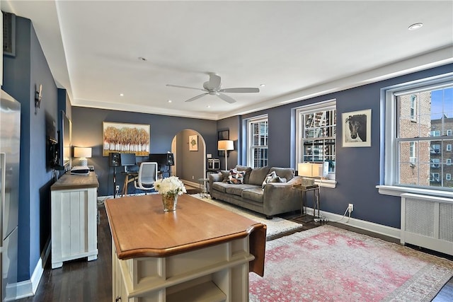 living room with dark hardwood / wood-style floors, ceiling fan, and radiator heating unit