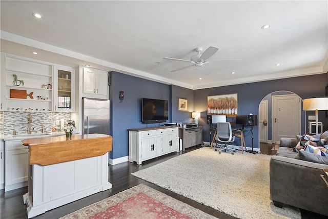 office area with ceiling fan, dark hardwood / wood-style flooring, and sink