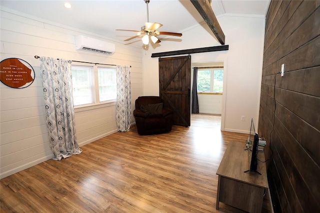 interior space with beam ceiling, a barn door, a wall mounted air conditioner, and hardwood / wood-style flooring