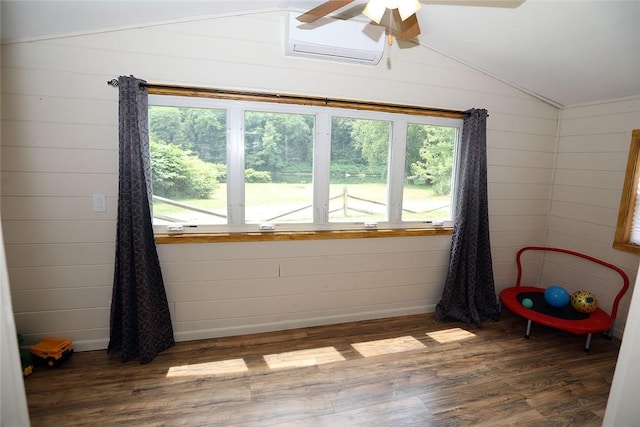 interior space with dark hardwood / wood-style floors, a healthy amount of sunlight, and wooden walls