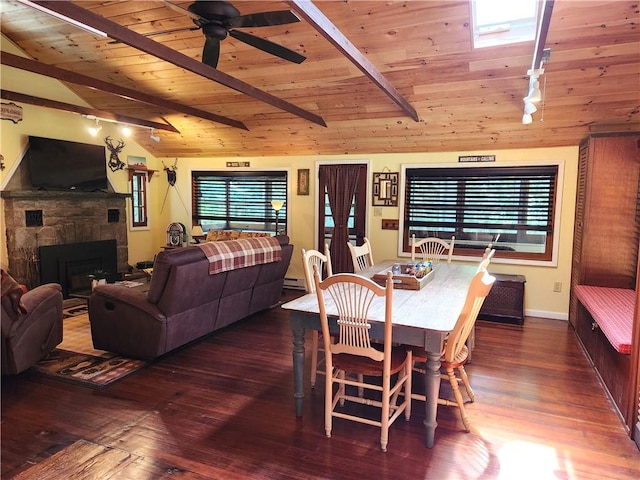 dining room with lofted ceiling with beams, a healthy amount of sunlight, and dark wood-type flooring