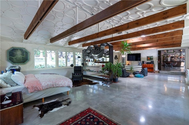 bedroom featuring beam ceiling and concrete floors