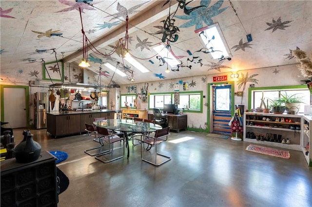 game room with concrete flooring, lofted ceiling with beams, and sink