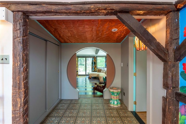 hall with tile patterned flooring and vaulted ceiling