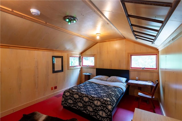 bedroom with multiple windows, wood walls, and vaulted ceiling