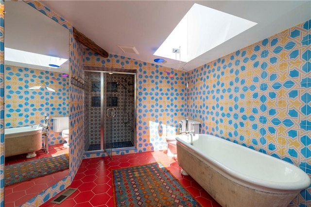 bathroom with a skylight, separate shower and tub, tile walls, tile patterned flooring, and toilet