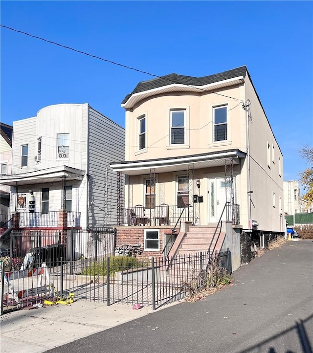 1604 Van Buren St, Bronx, NY 10460 - view of front of home featuring covered porch, a fenced front yard, and stucco siding
