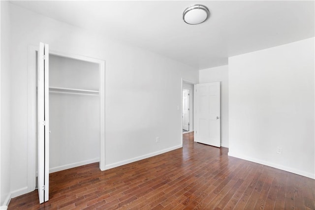 unfurnished bedroom featuring a closet and dark hardwood / wood-style flooring