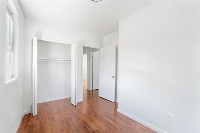 unfurnished bedroom with wood-type flooring and a closet