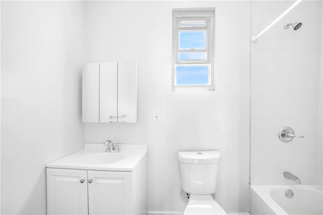 full bathroom featuring vanity, tiled shower / bath combo, and toilet