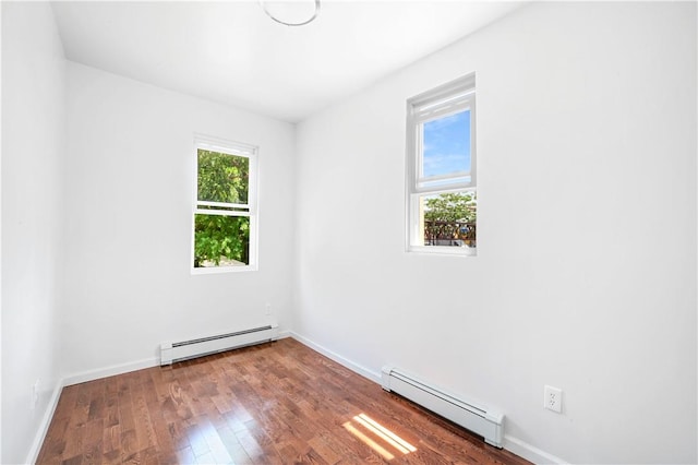 spare room featuring hardwood / wood-style flooring and baseboard heating