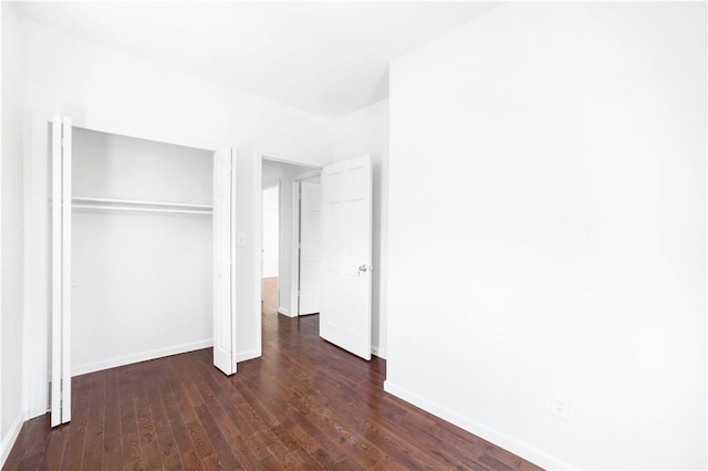 unfurnished bedroom featuring dark wood-type flooring and a closet