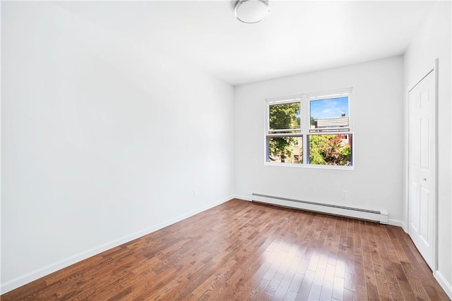 unfurnished bedroom featuring hardwood / wood-style floors and a baseboard radiator