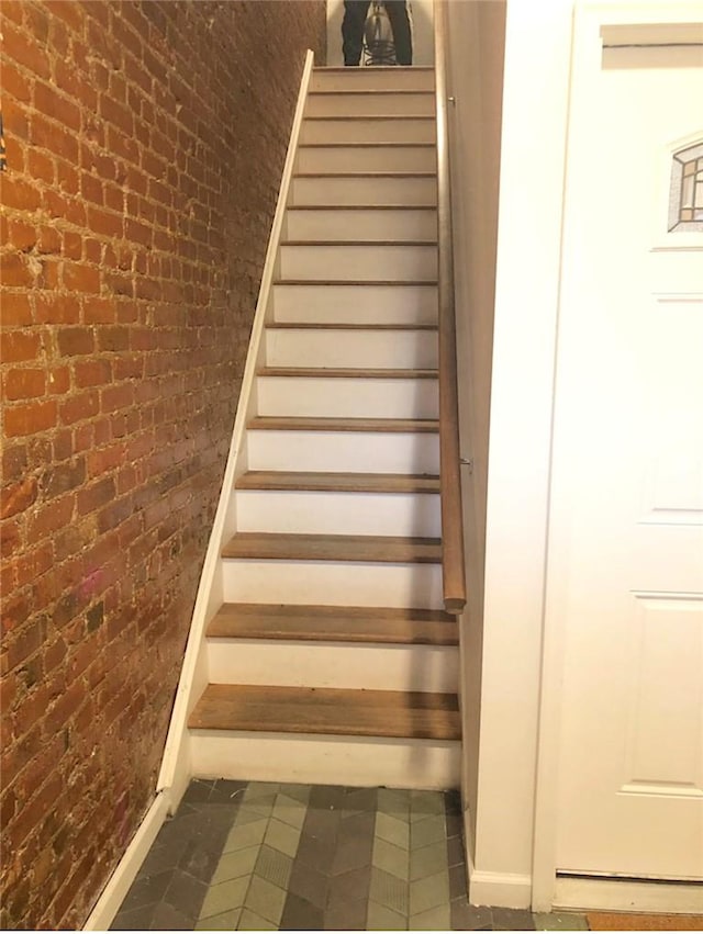 staircase with brick wall