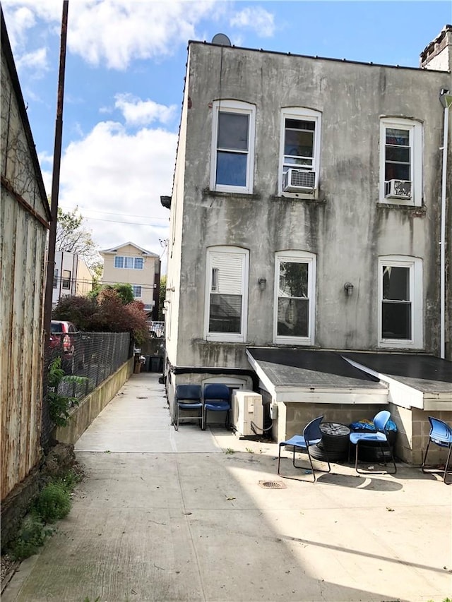 rear view of property with cooling unit and a patio