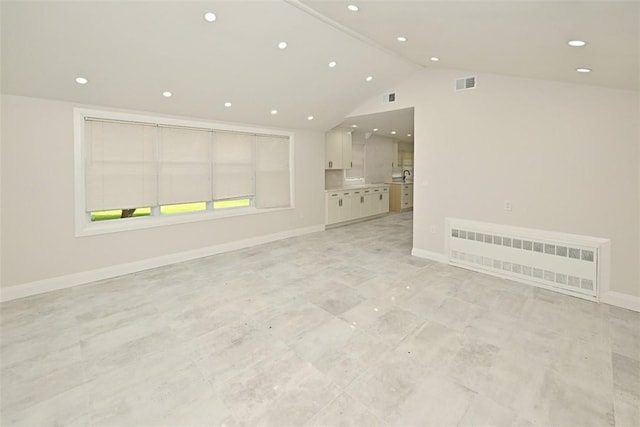 unfurnished living room featuring radiator and vaulted ceiling