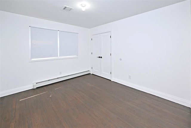 unfurnished room with dark hardwood / wood-style flooring and a baseboard radiator