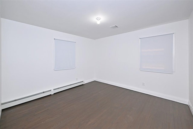 spare room featuring dark hardwood / wood-style floors and a baseboard heating unit