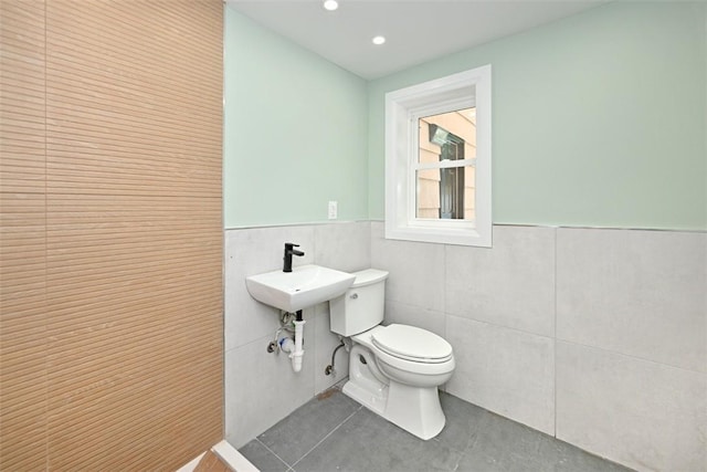 bathroom with tile patterned floors, tile walls, and toilet