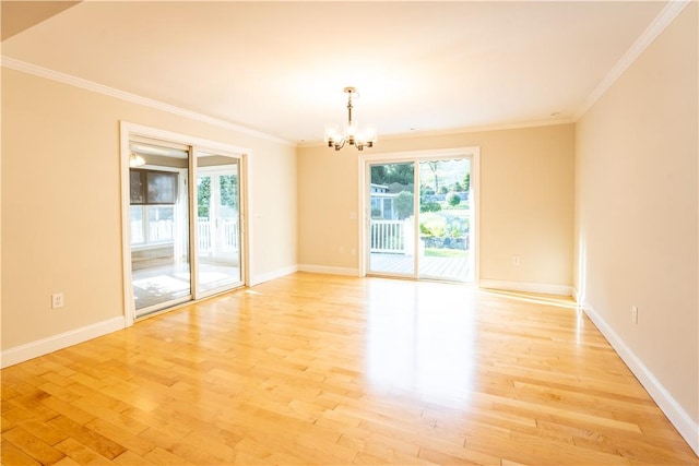 spare room with crown molding, light hardwood / wood-style flooring, and a notable chandelier