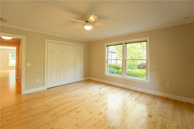 unfurnished bedroom with light wood-type flooring, a closet, ceiling fan, and ornamental molding