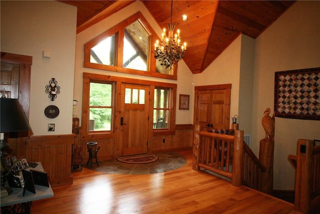 foyer entrance featuring wood ceiling, high vaulted ceiling, wood-type flooring, and an inviting chandelier