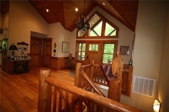 stairs featuring wood-type flooring, wood ceiling, high vaulted ceiling, and a chandelier