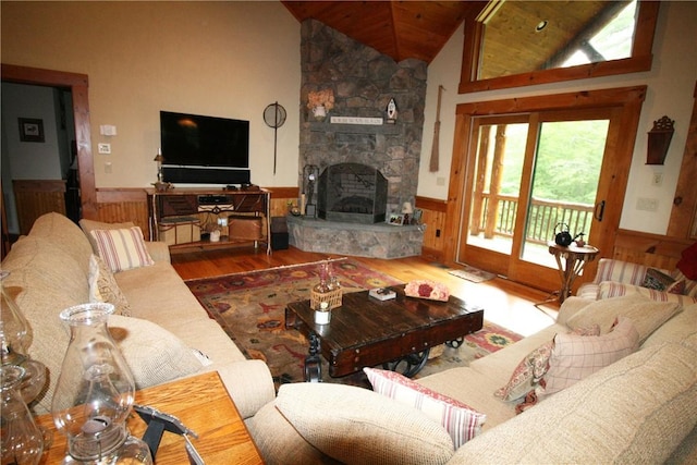 living room featuring a stone fireplace, wooden ceiling, high vaulted ceiling, and wood-type flooring