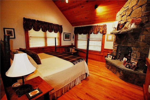 bedroom featuring light hardwood / wood-style flooring, vaulted ceiling, multiple windows, and wooden ceiling