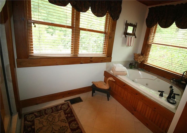 bathroom with tile patterned floors, plenty of natural light, and a bathing tub