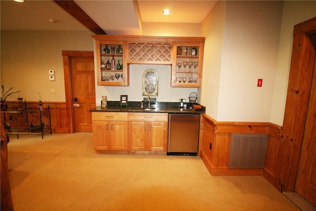 bar featuring wood walls, stainless steel fridge, light colored carpet, and sink