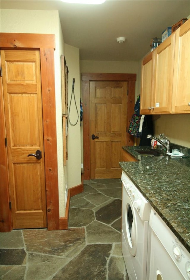 clothes washing area featuring cabinets, washer / dryer, and sink