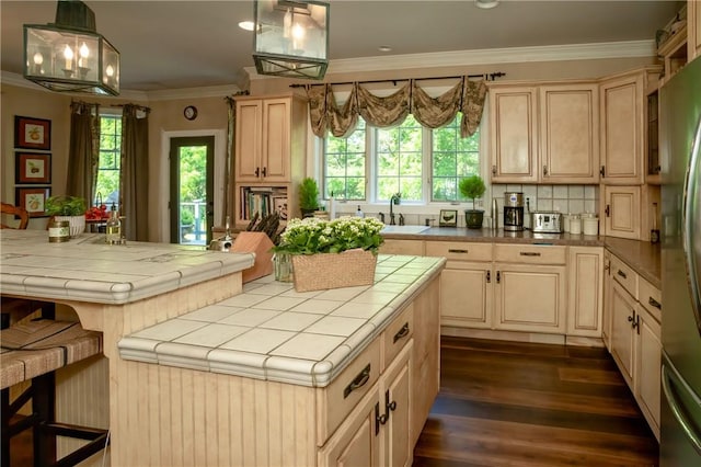 kitchen featuring sink, hanging light fixtures, dark wood-type flooring, tile countertops, and ornamental molding