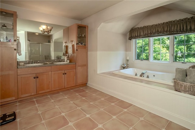 bathroom with tile patterned floors, vanity, independent shower and bath, and vaulted ceiling