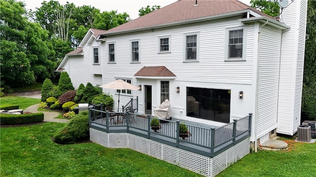 rear view of house featuring a lawn and central AC