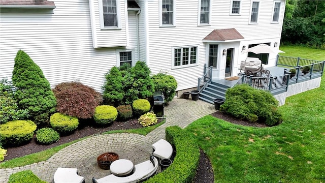 view of exterior entry with a patio area and a lawn