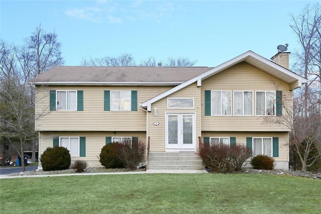 bi-level home featuring a front yard and french doors