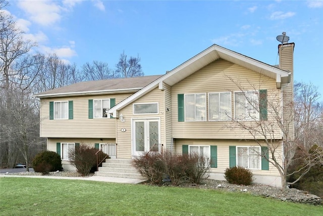 split foyer home featuring french doors and a front lawn