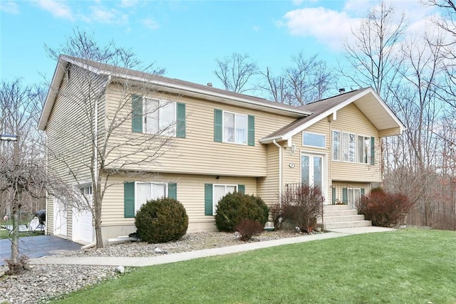 bi-level home featuring a garage and a front lawn