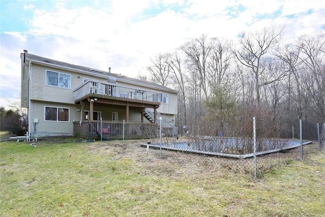 rear view of house featuring a deck and a lawn