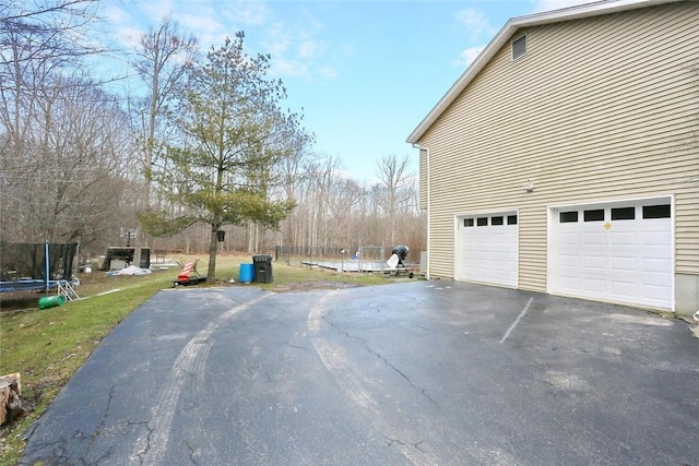 exterior space with a garage and a trampoline