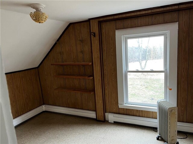 interior space featuring wood walls and a baseboard heating unit