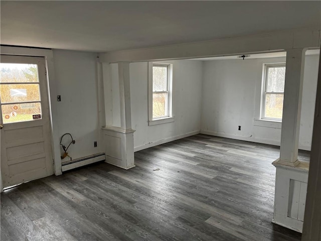 interior space with dark wood-type flooring, plenty of natural light, and a baseboard heating unit