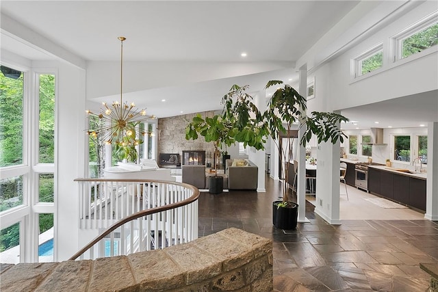 interior space with a chandelier, high vaulted ceiling, and sink