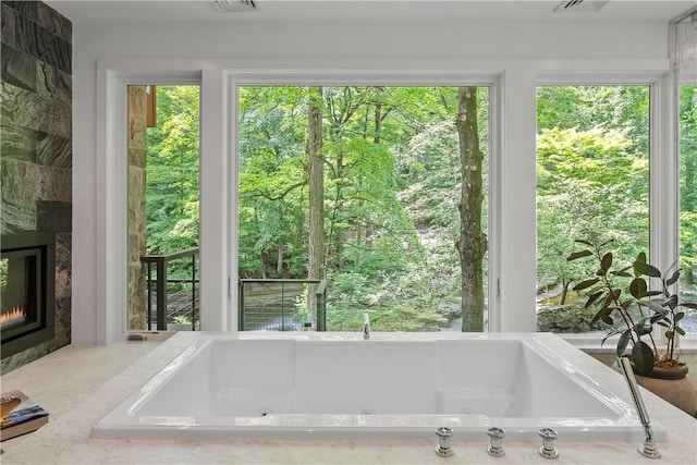 bathroom with a large fireplace and a wealth of natural light