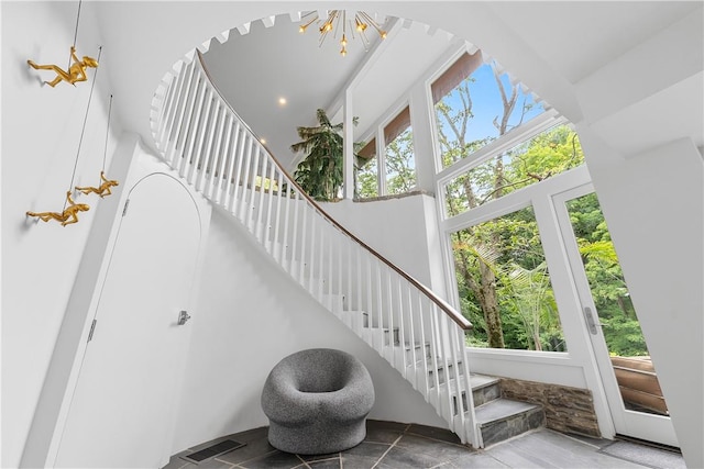 stairs with a healthy amount of sunlight and a high ceiling