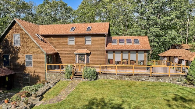 rear view of house with a yard and a wooden deck